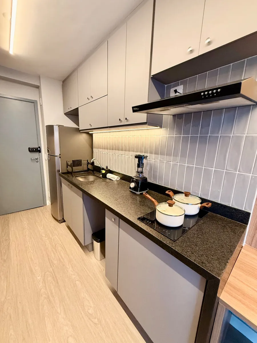 Cozinha compacta com cooktop e armários claros