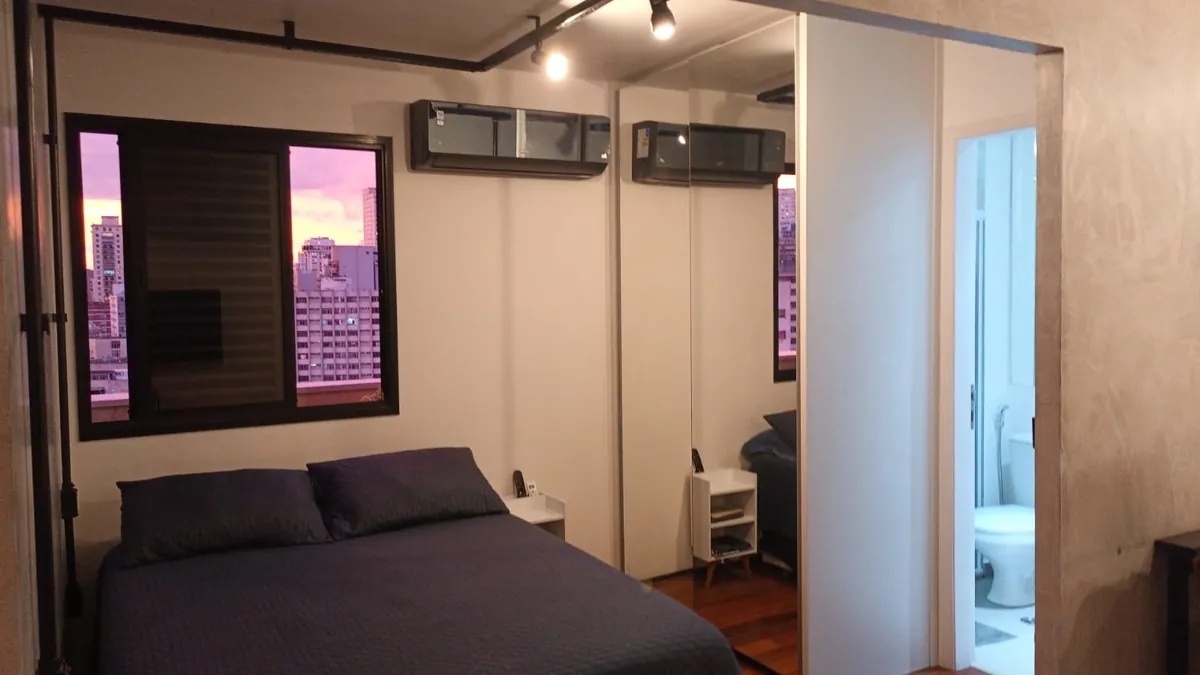 Quarto do apartamento em Higienópolis com cama de casal e janela para a cidade